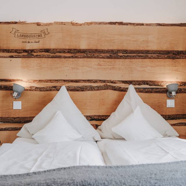 Hotelbett mit Holzverkleidung